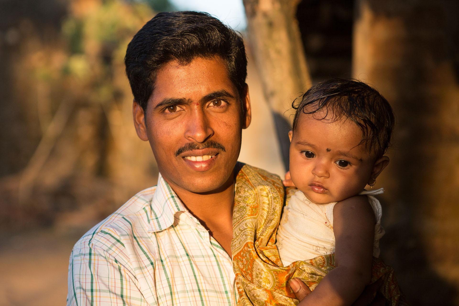 Indian man with his child on his arms
